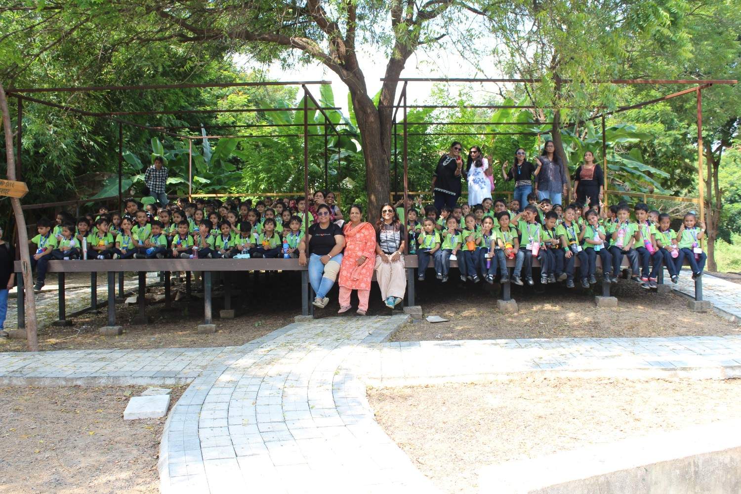 Large group photo of students and teachers on wooden deck