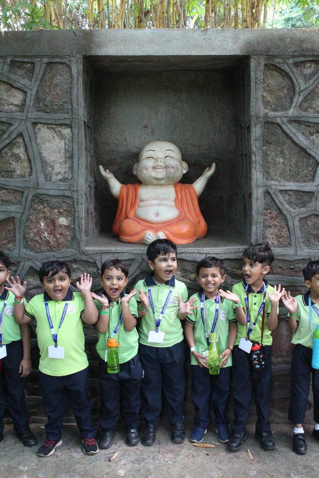 Happy students with Laughing Buddha statue