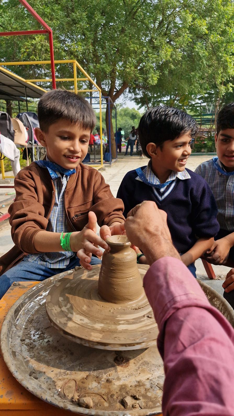 Student shaping clay on pottery wheel