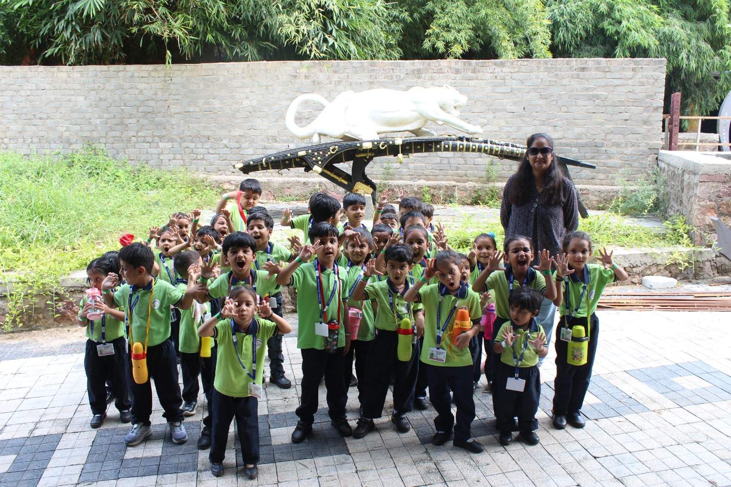 School kids posing with white tiger statue