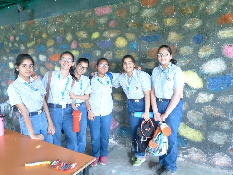 Girls posing together near stone wall at campsite