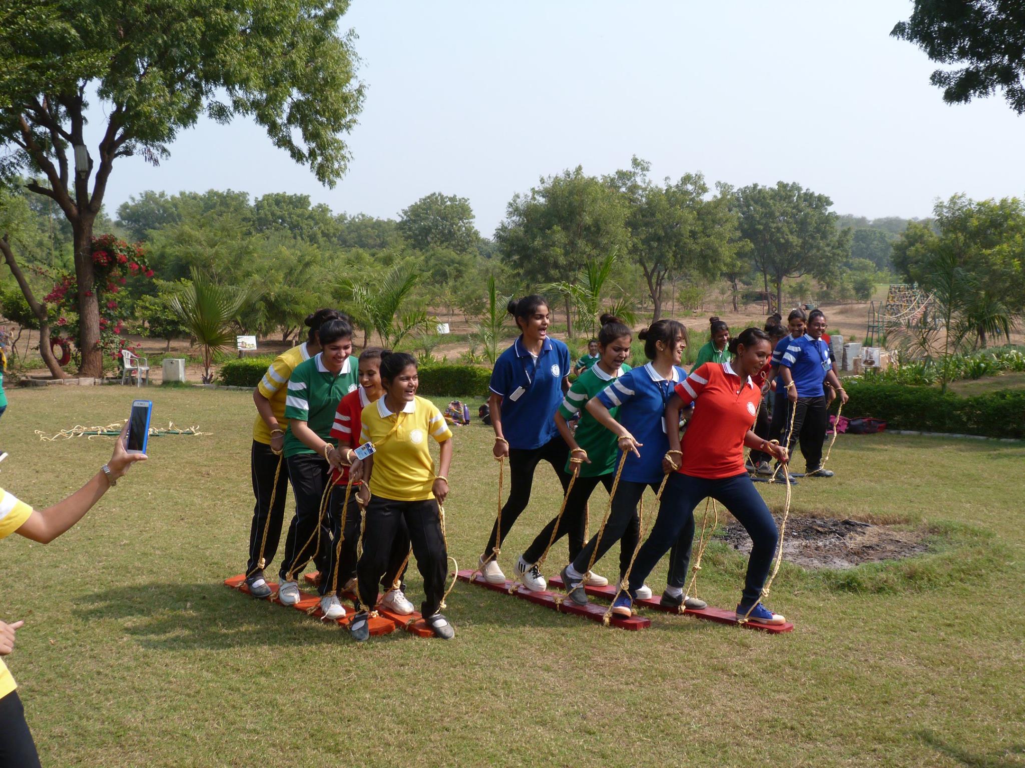 Girls team coordinating steps in plank walk game
