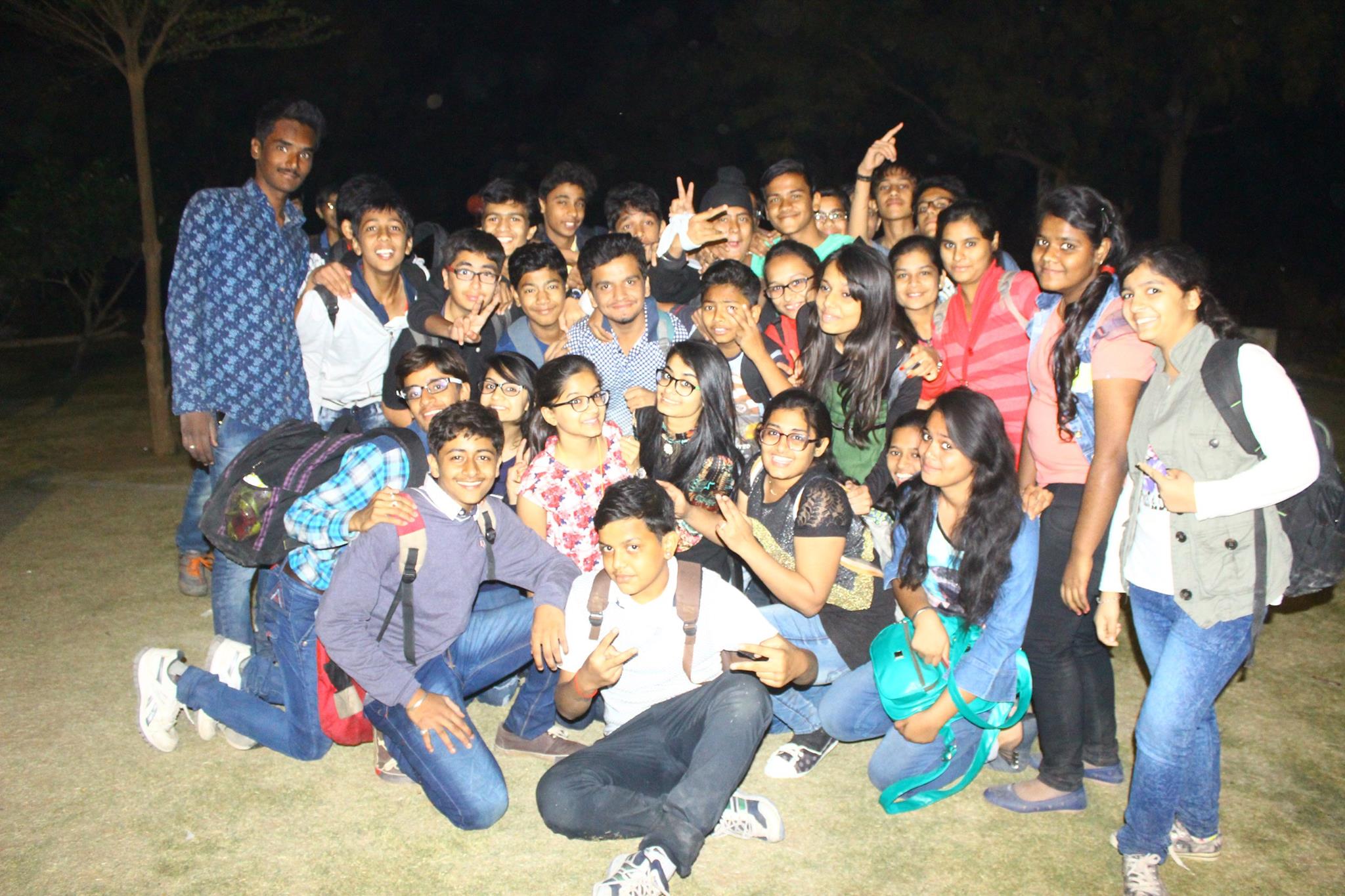 Happy students posing for group photo at night