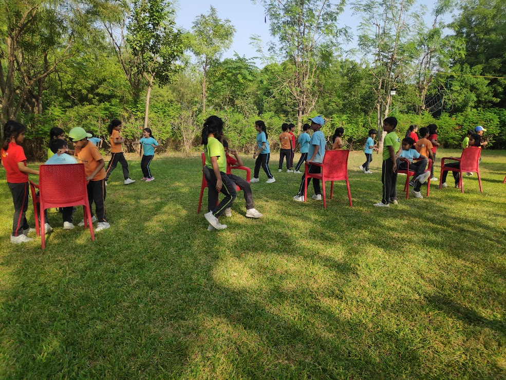 Students playing musical chairs on the lawn