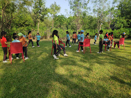 Musical chairs game with red chairs on the lawn