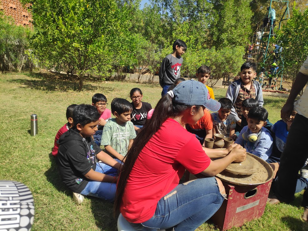 Outdoor pottery class with instructor on the grass