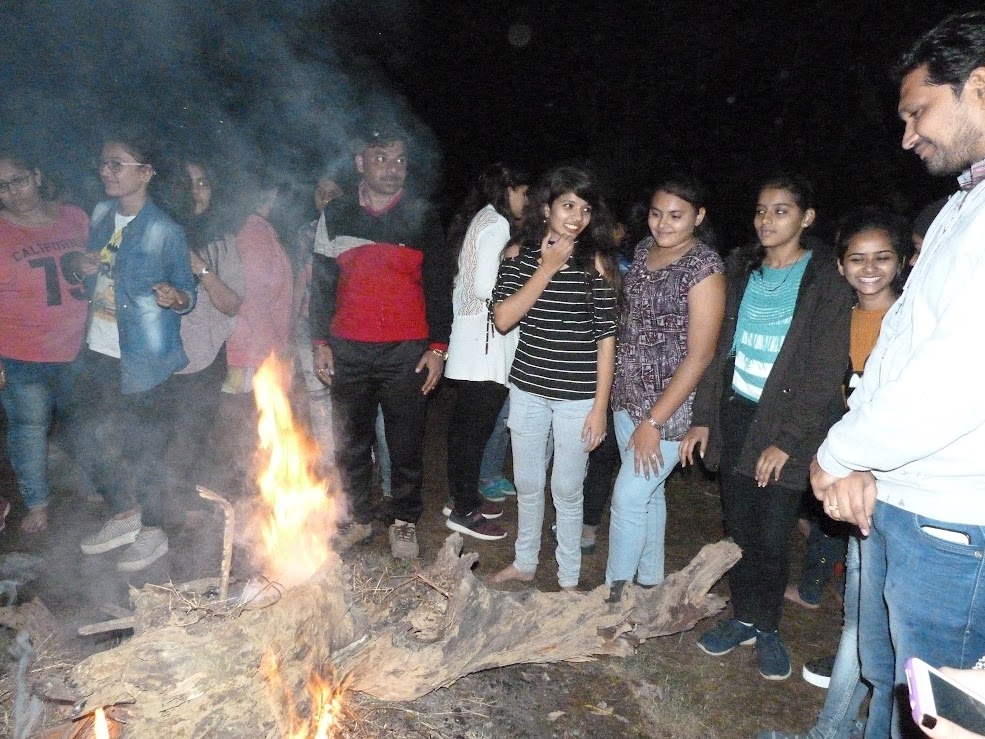 Staff and students standing near the campfire