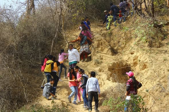 Students helping each other climb sandy hill
