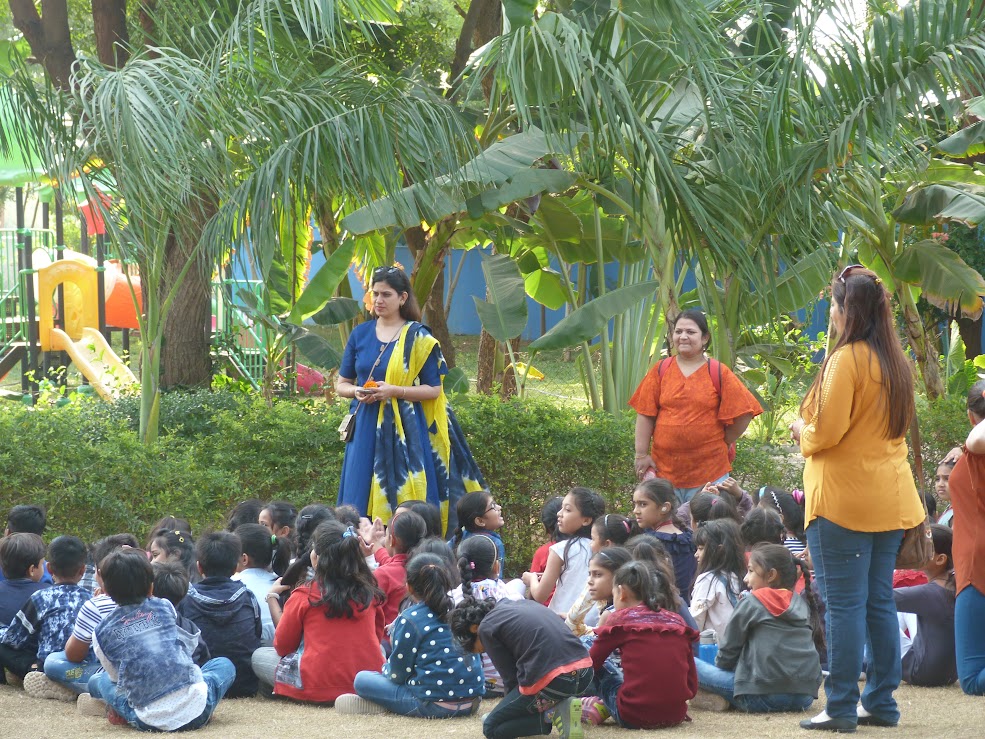 Teachers supervising students sitting on the lawn