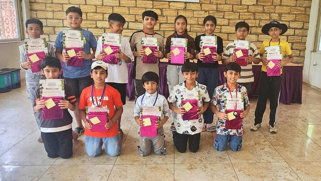 A group of smiling campers holding their Memory Leaf certificates and pink wrapped gifts