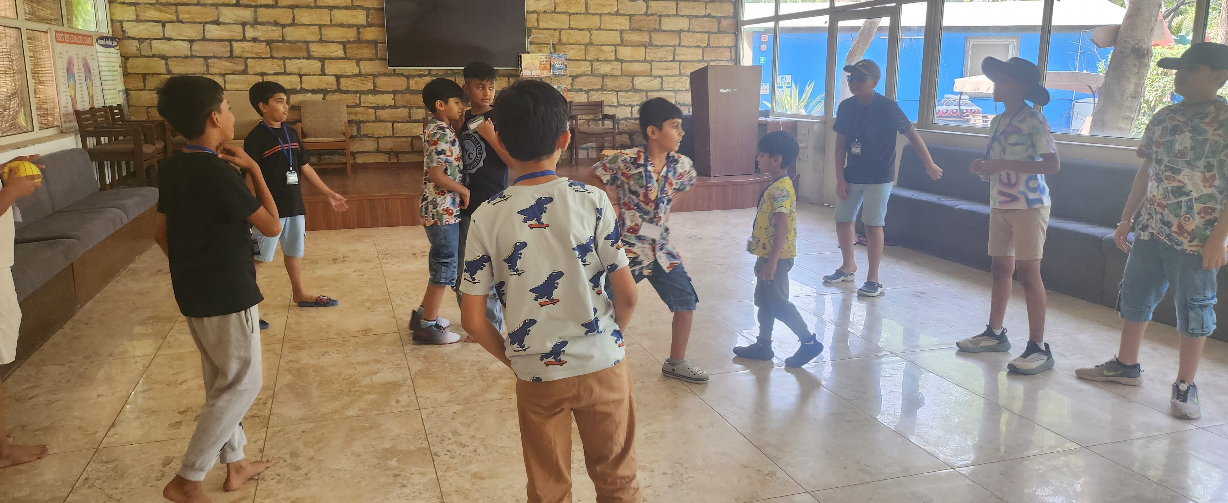 Children participating in an active indoor group game in a stone-walled hall