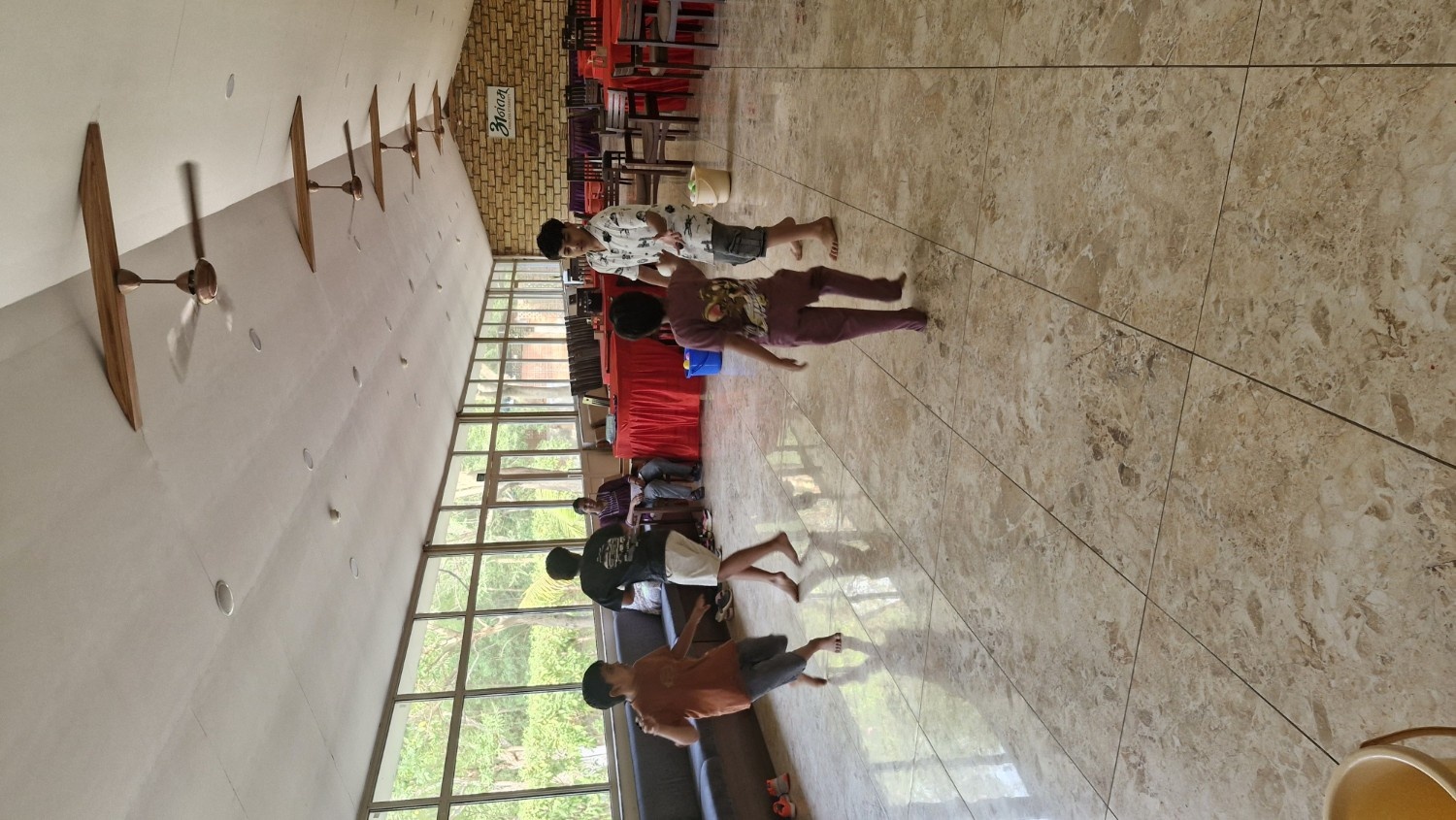 Kids running and playing an energetic ball toss game with buckets