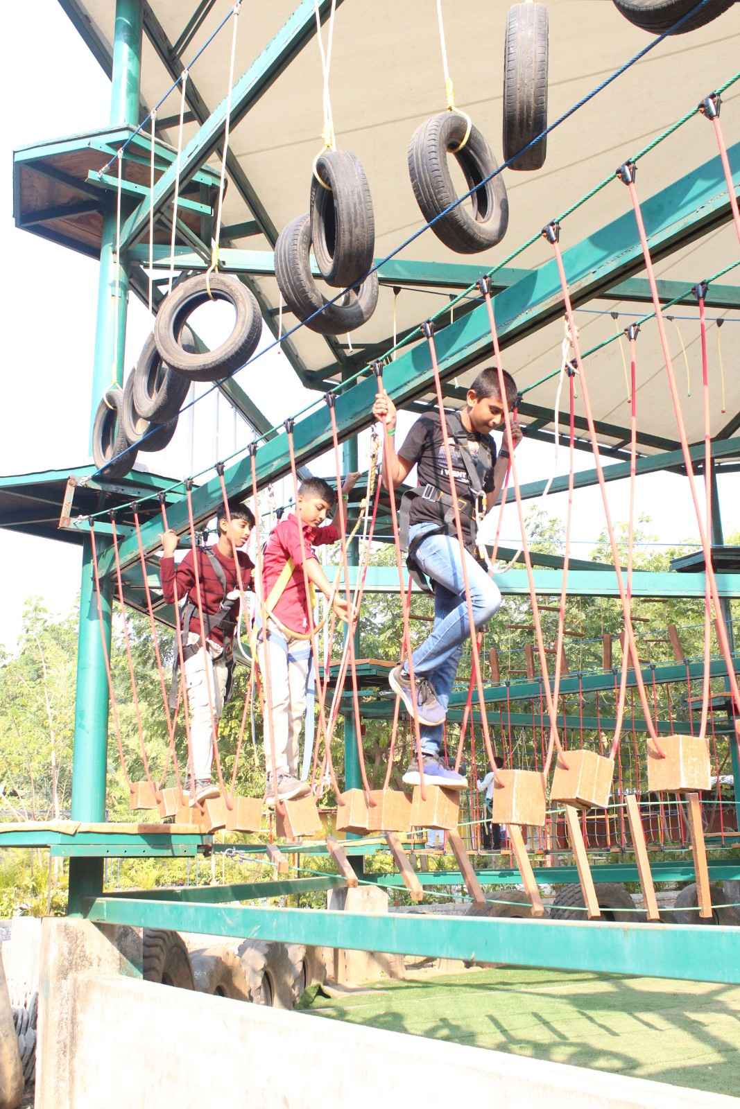 Boys crossing tire bridge obstacle