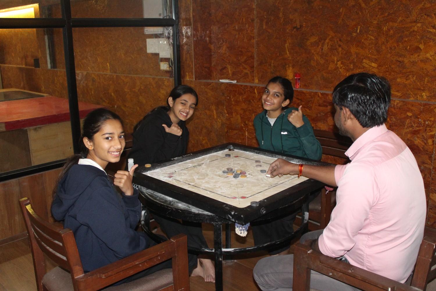 Girls playing carrom board game