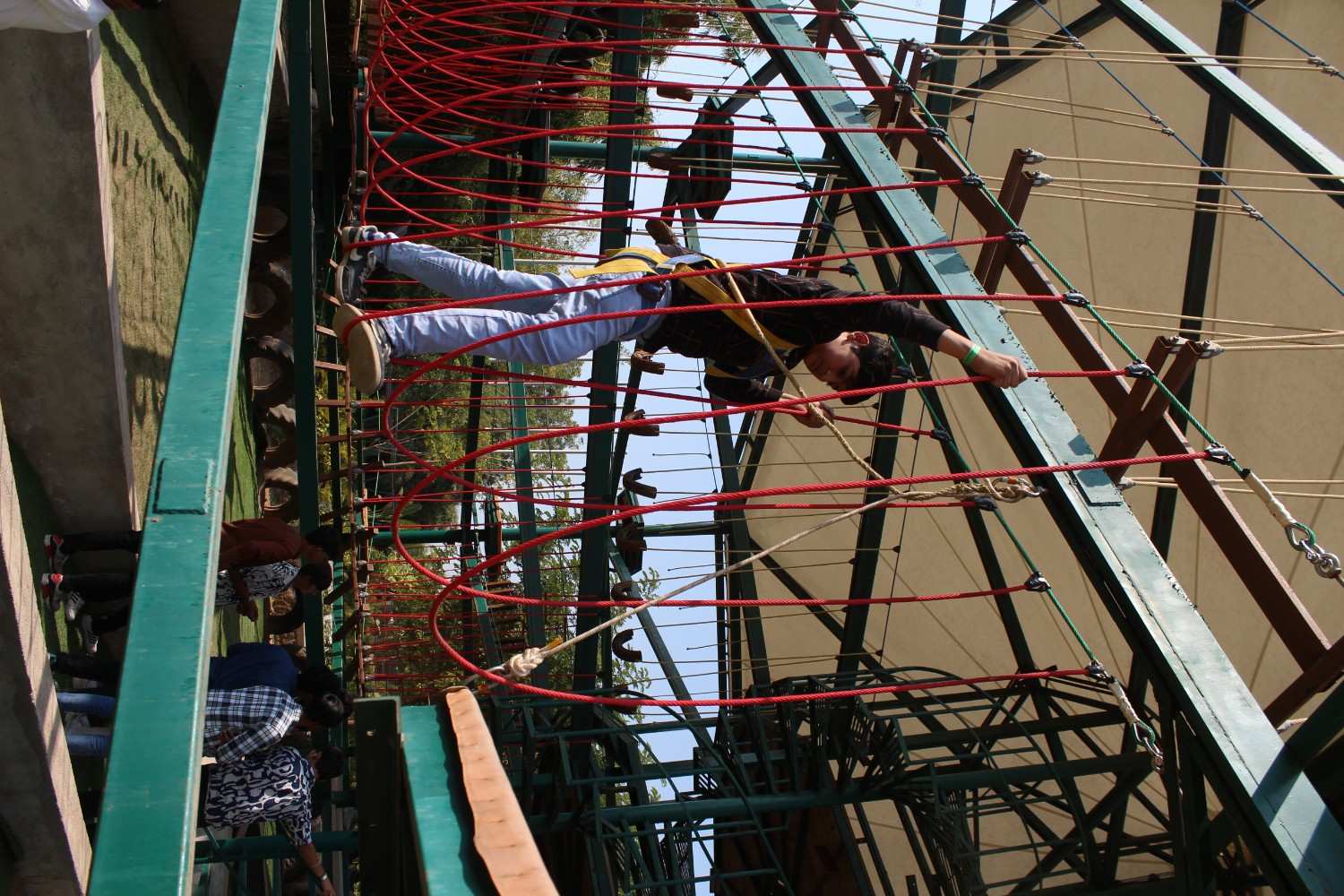 Student focusing on a suspended rope bridge at an outdoor resort