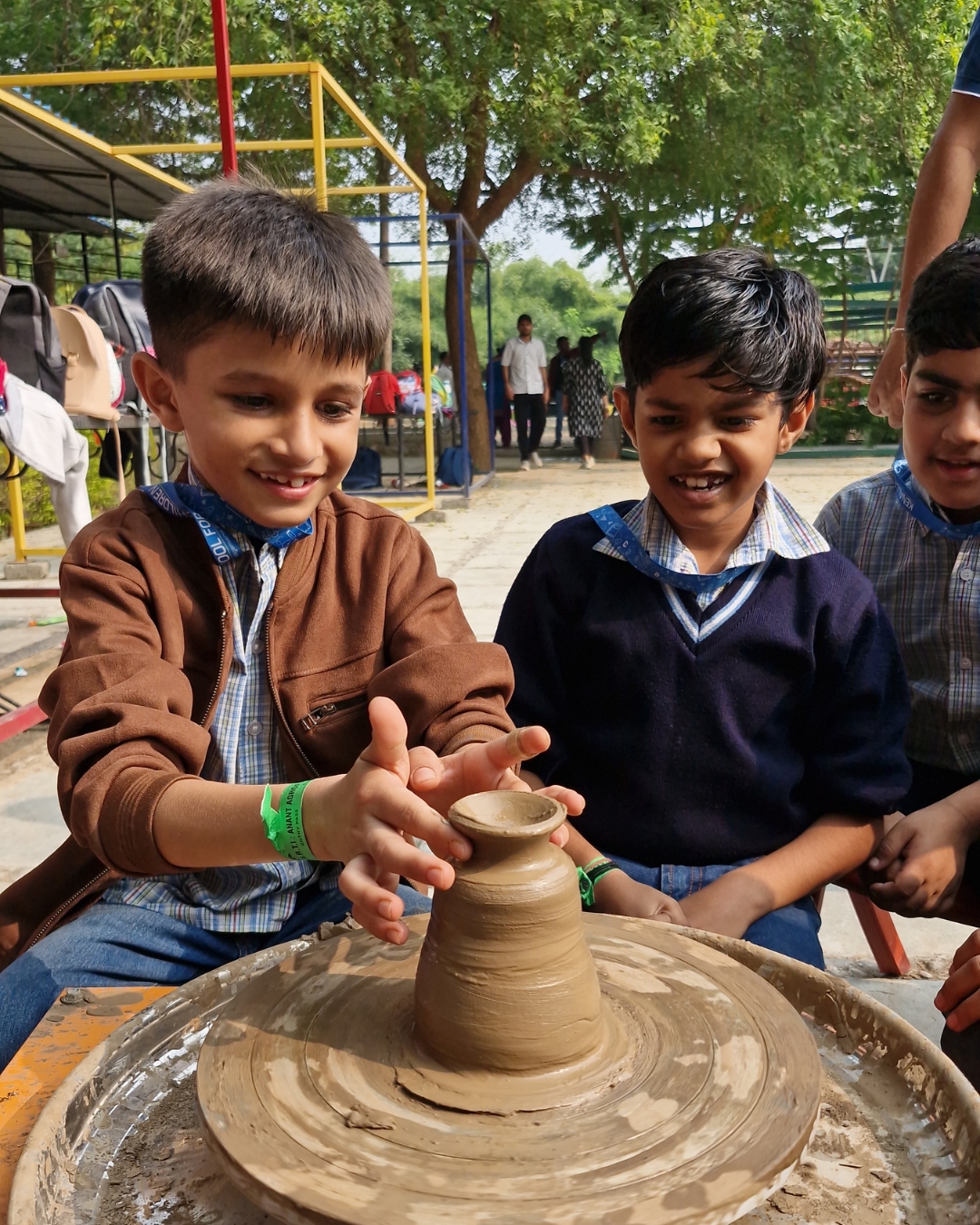 Children learning pottery making on a clay wheel