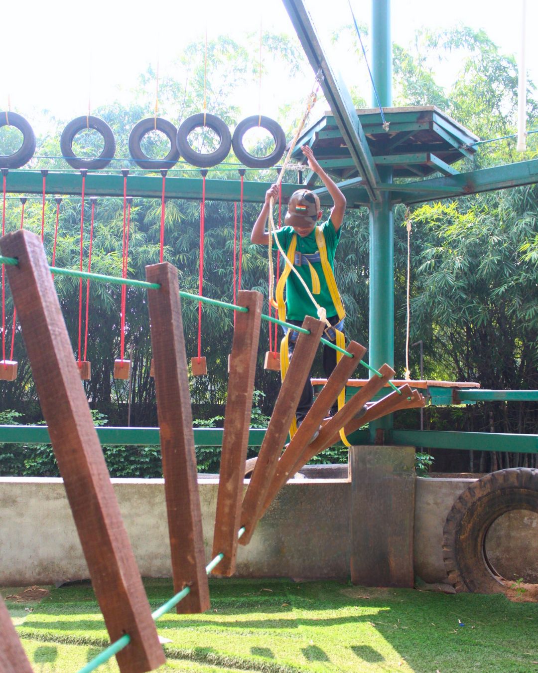 Child crossing a zigzag wooden plank bridge
